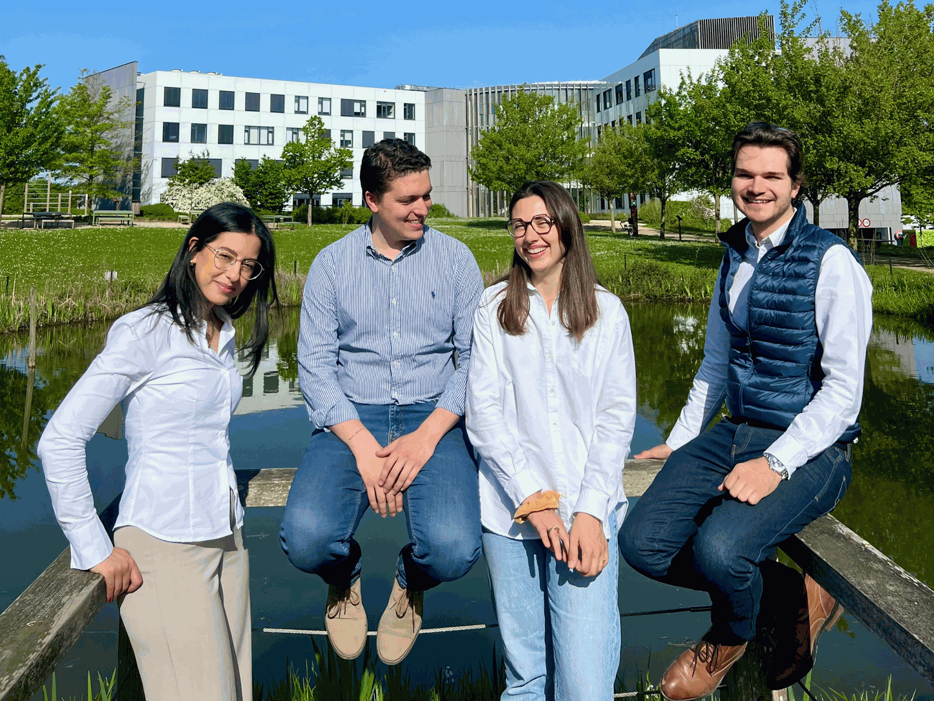 Equipe Guidoo Equipe de Guidoo, partenaire Odoo en Belgique adossé à une barrière devant un point d'eau